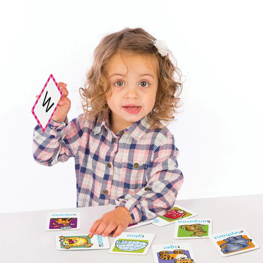 Child holding a card with a letter, surrounded by educational cards on a white background