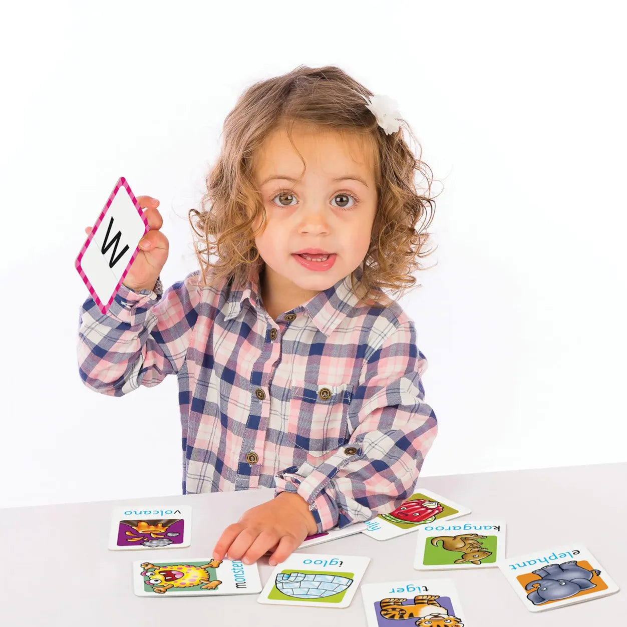 Child holding a card with a letter, surrounded by educational cards on a white background