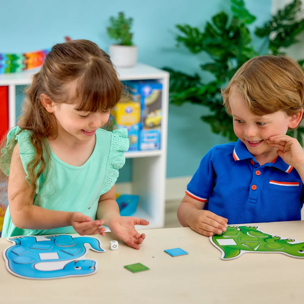 Two children playing with educational toys at a table in a classroom setting.